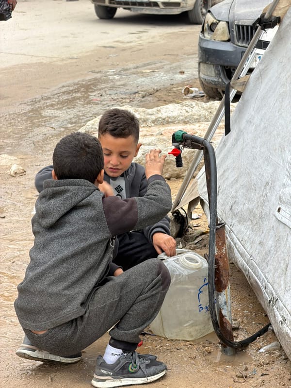 Children access makeshift water tap in Gaza