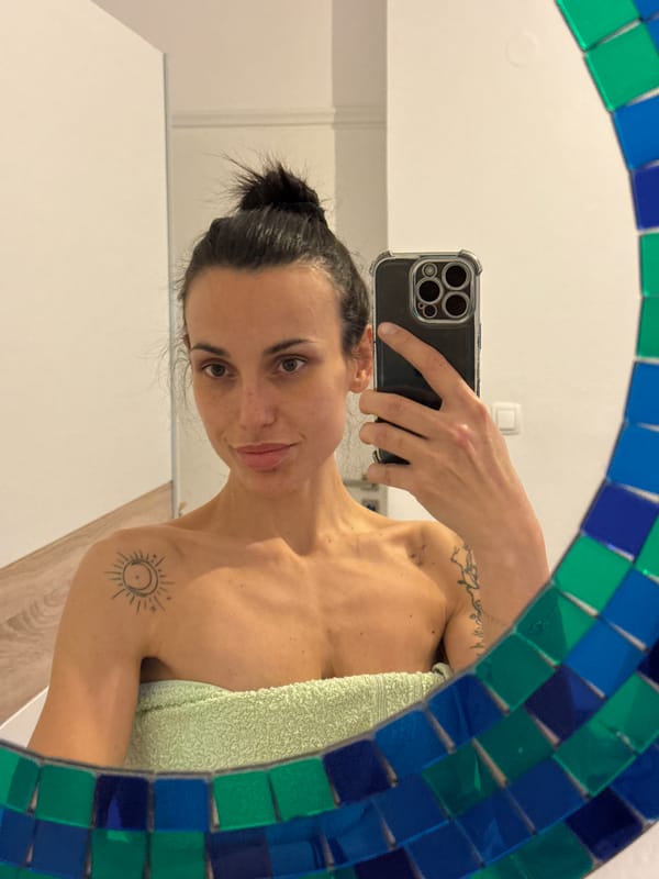 Woman takes bathroom mirror selfie in Chania, Greece