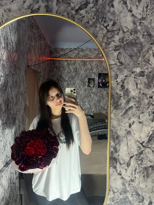 Woman takes mirror selfie with red roses in Moldova