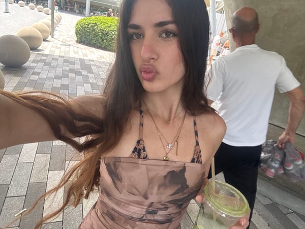 Woman takes selfie near decorative animal fountain in Aventura