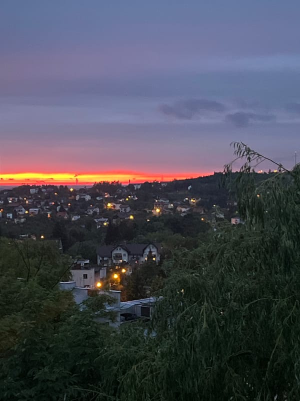 Dramatic sunset illuminates hillside city during evening hours