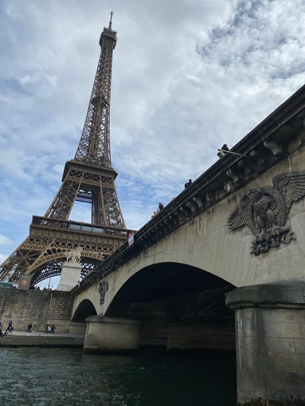 Tourist boat operates near Eiffel Tower on Seine River
