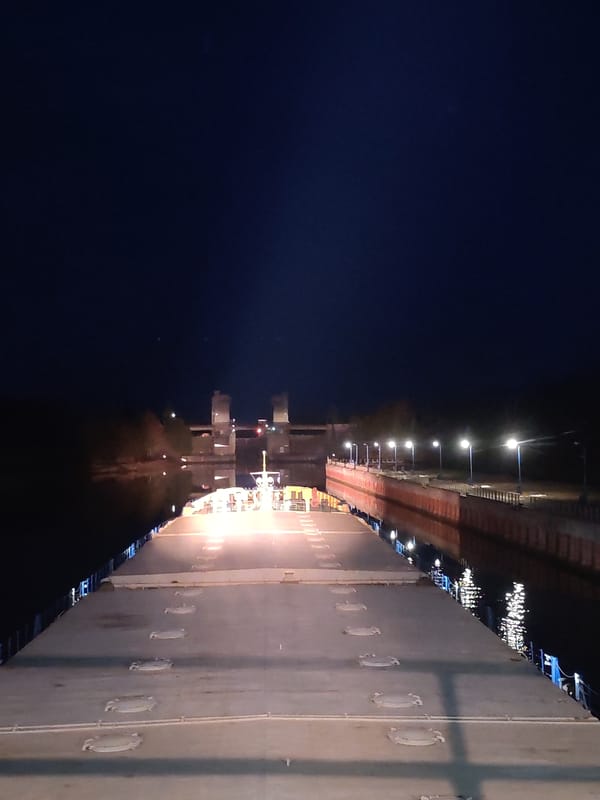 Cargo ship navigates illuminated waterways near Vytegra at night