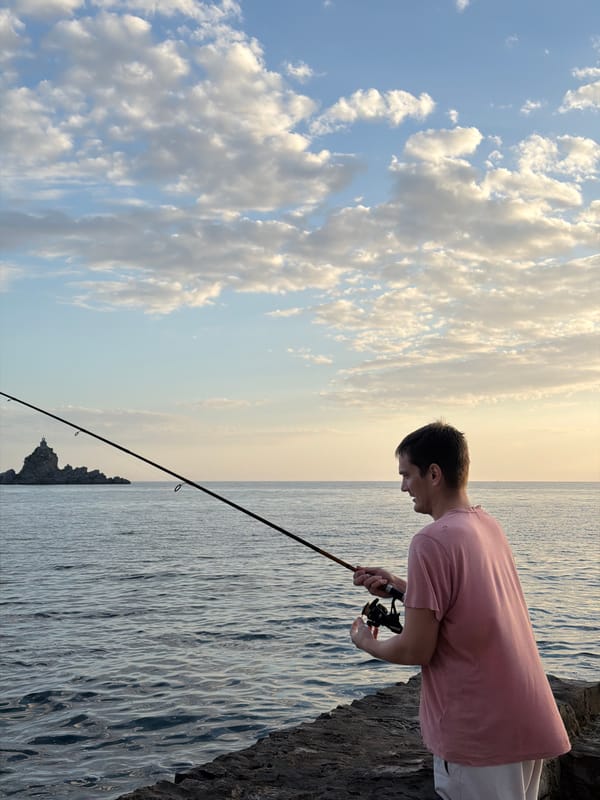 Man fishes from rocky shore in Petrovac, Montenegro