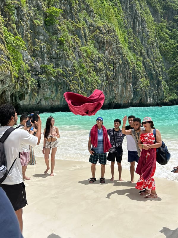 Ao Nang beach busy with visitors beneath limestone cliffs