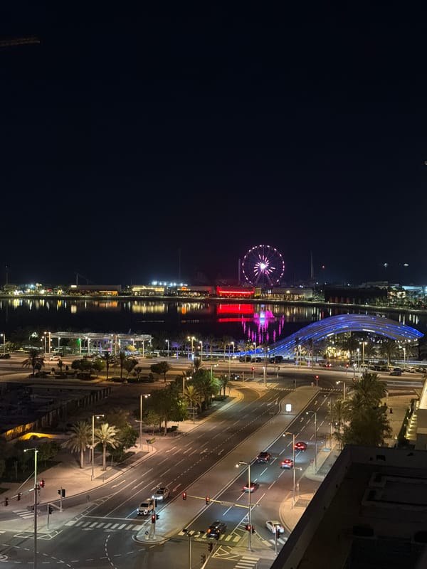 Pink-lit Ferris wheel observed from high vantage point in Lusail