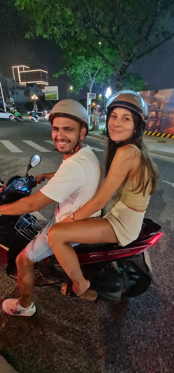 Families ride motorcycles through Đà Nẵng streets at night