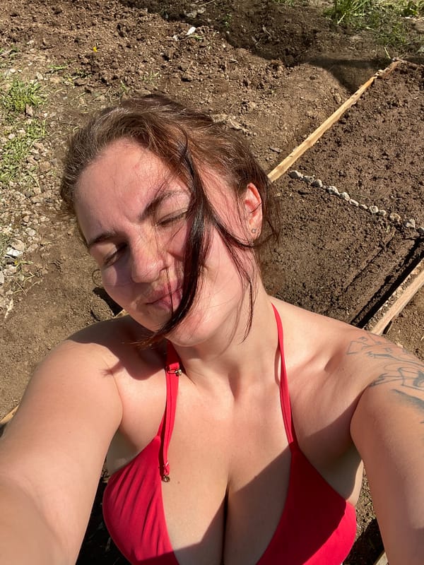 Woman gardens in red bikini in suburban Moscow area