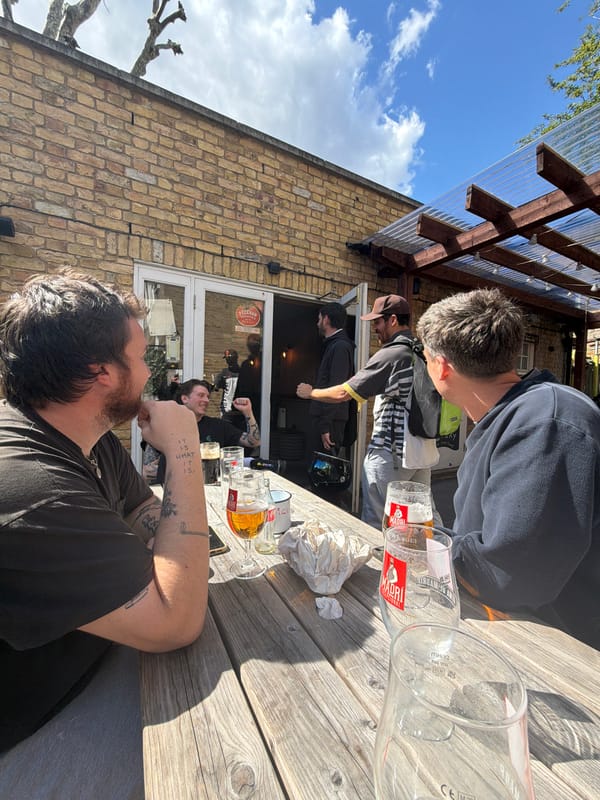 Three men gather at London pub outdoor seating area