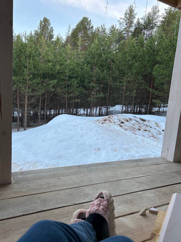 Girl relaxes in hammock on snowy porch in Russia