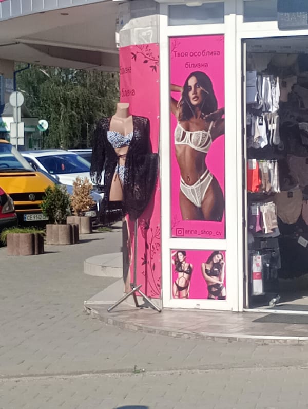 Strolling past retail storefronts on a sunny afternoon