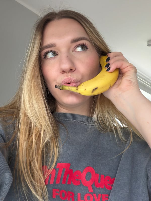 Woman poses with banana as phone and selfie prop