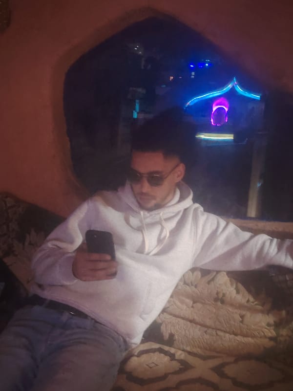 Man uses smartphone in traditional alcove, Tangier