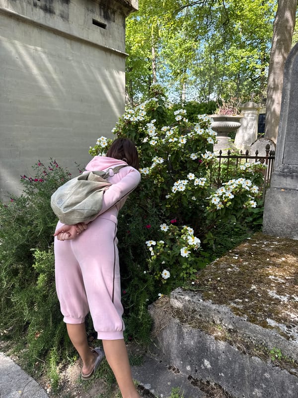 Woman in pink sweatsuit lies in Paris garden