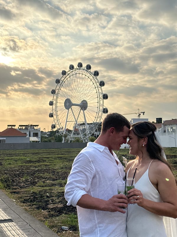 Newlyweds celebrate with drinks near Ferris wheel in North Kuta