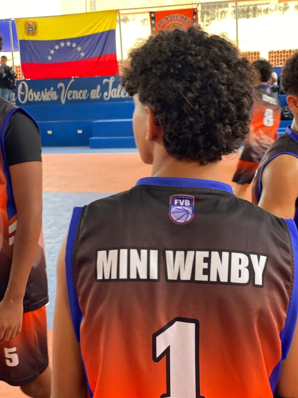 Youth basketball game played at Valencia court with inspirational mural
