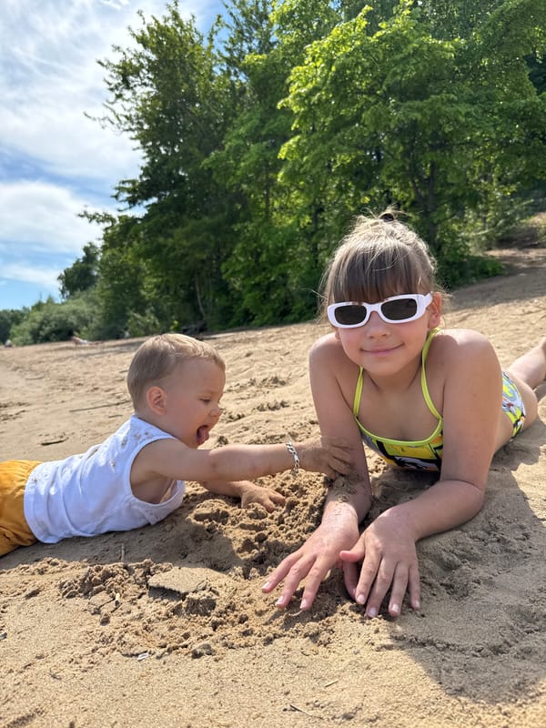 Children play on sandy beach in Rusanovo, Russia