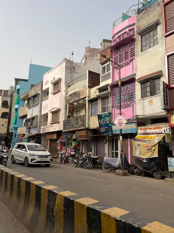 Man tends small street fire in Varanasi commercial district