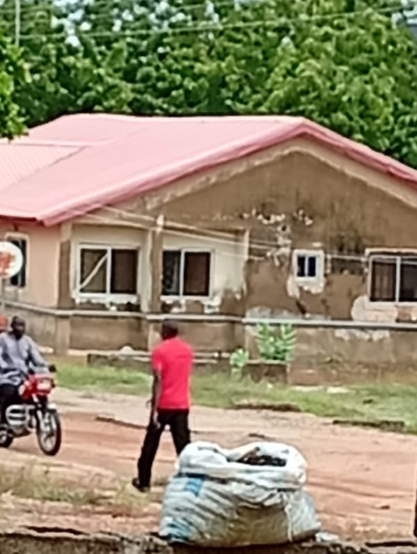 Daily life observed near colorful-roofed buildings on dirt roads