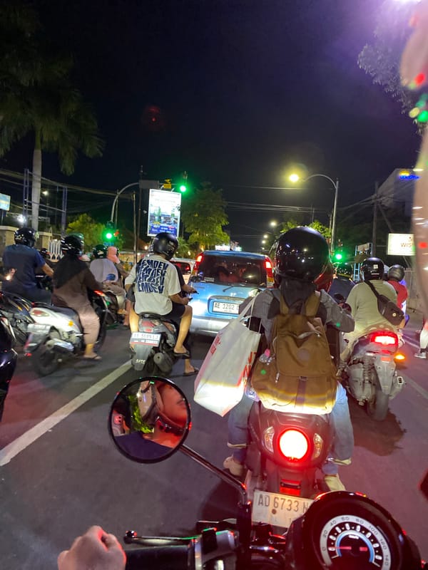 Motorcyclist documents nighttime traffic scene in Madiun, Indonesia
