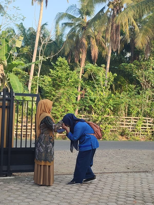 Two women photographed near gate in Blangriek, Indonesia