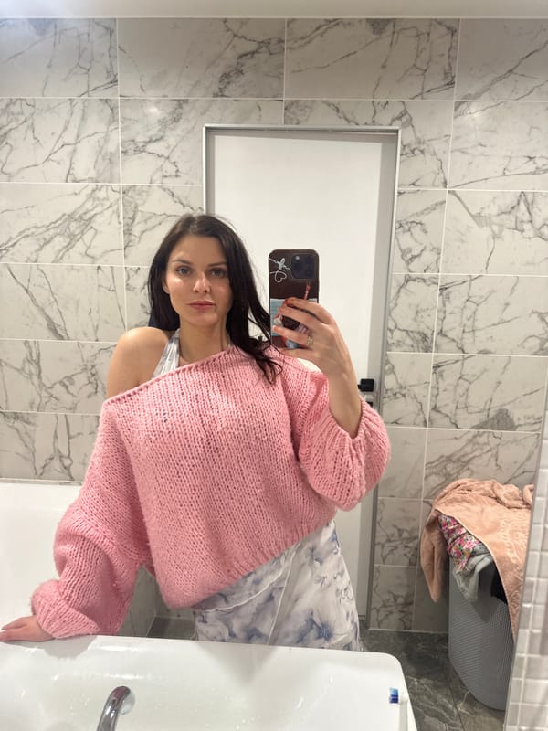 Mirror selfie highlighting a layered off-shoulder sweater look.