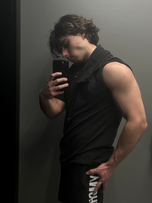 Person takes mirror selfie in black athletic wear
