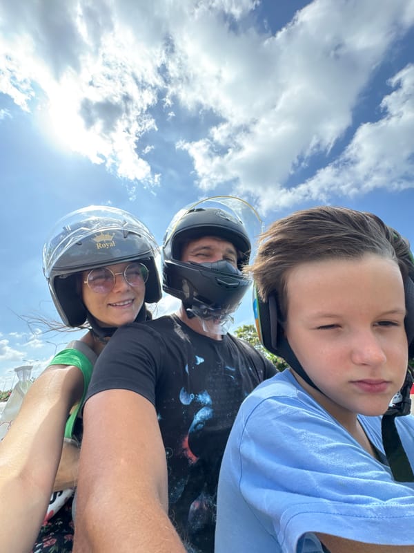 Three people ride motorcycle in sunny Mui Ne Vietnam