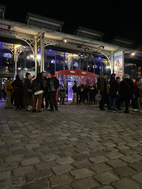 Evening crowd lines up outside ornate Paris building