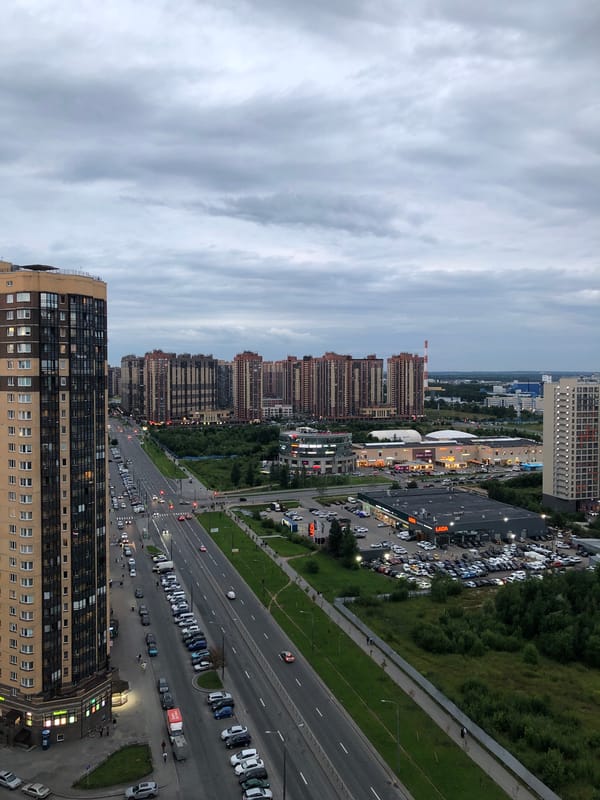 Aerial sweep over a cloudy Russian urban district with Lada dealership
