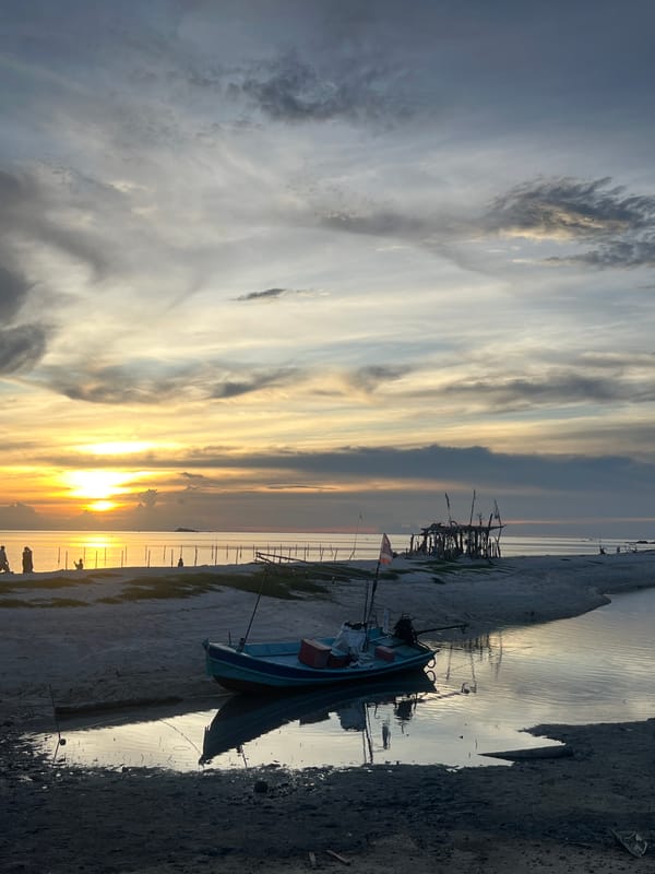Sunset at the beach: kayaks, fishing boats, and golden skies