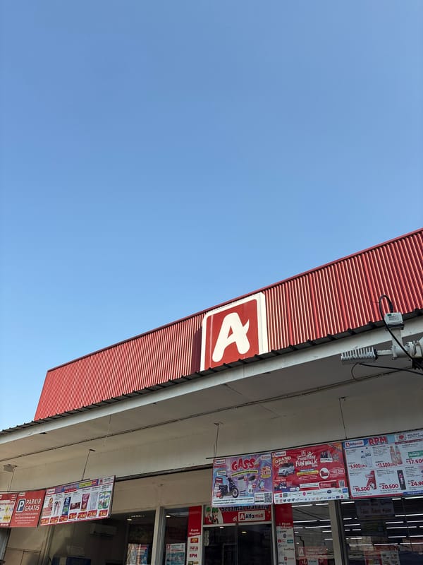North Jakarta street and market activity around a local Alfamidi