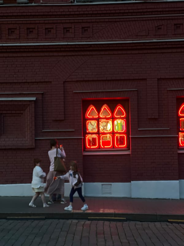 Neon-lit building draws pedestrians in Khimki, Russia