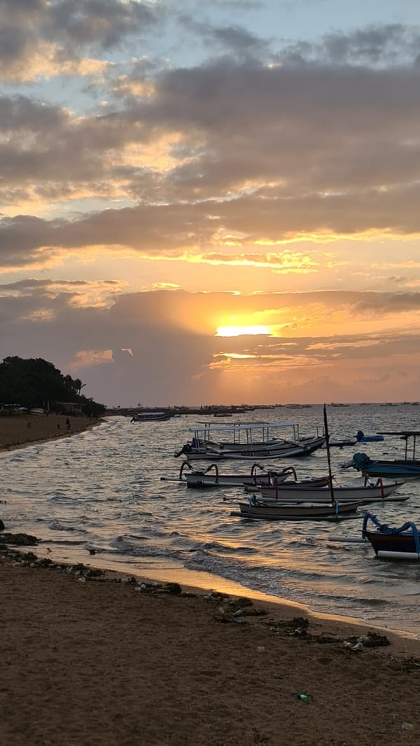 Bali beach at golden hour: boats, dogs, and a slow sunset