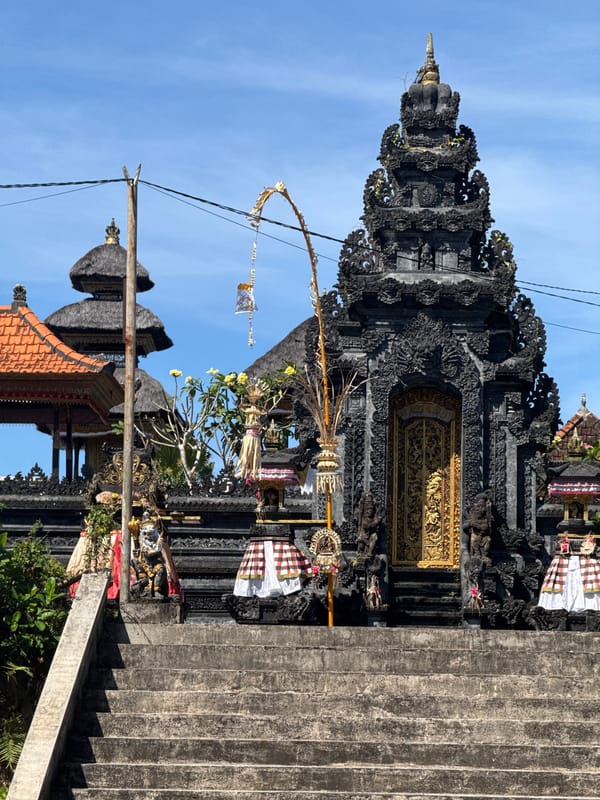 Temple architecture and ocean play on a sunny Bali day