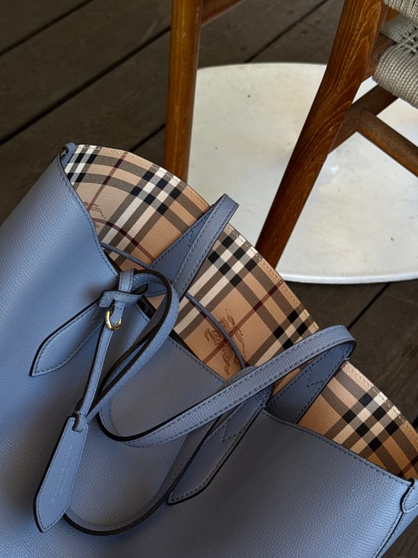 Blue leather tote bag spotted beside wooden chair indoors