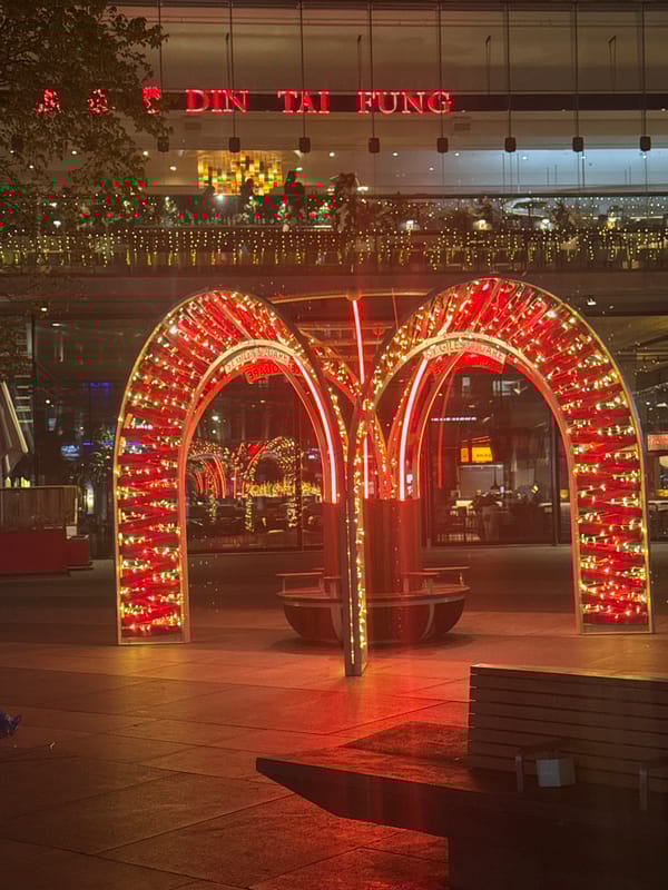 London nighttime scene features illuminated red arch and lit buildings