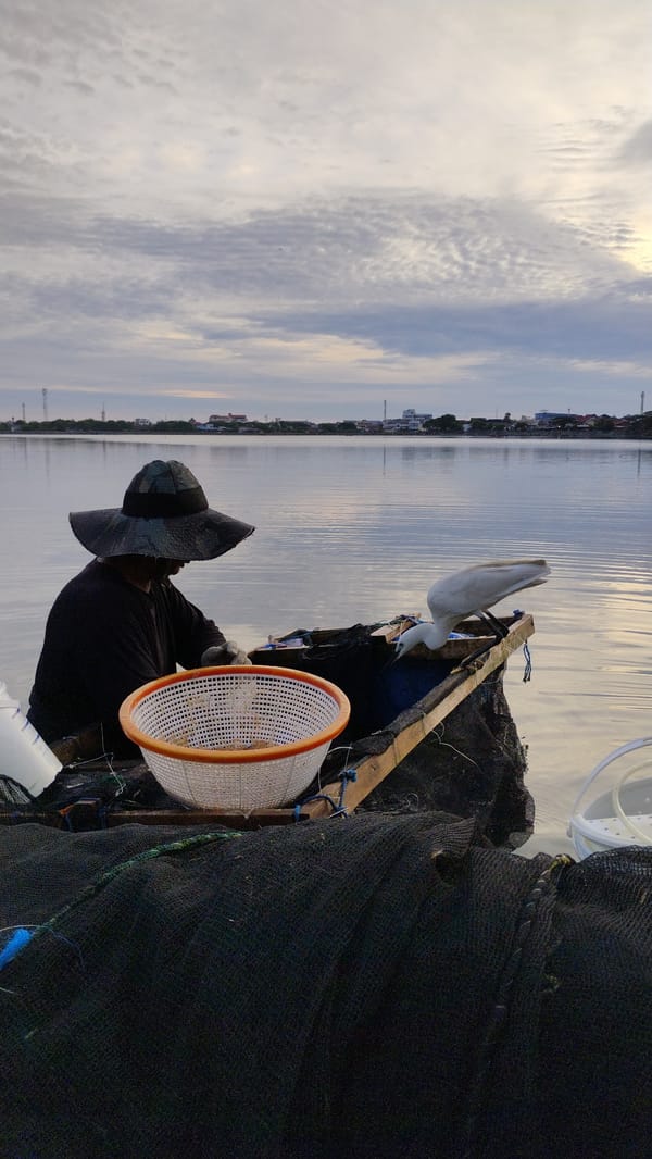 Boat work on calm coastal waters at sunset, Lhokseumawe