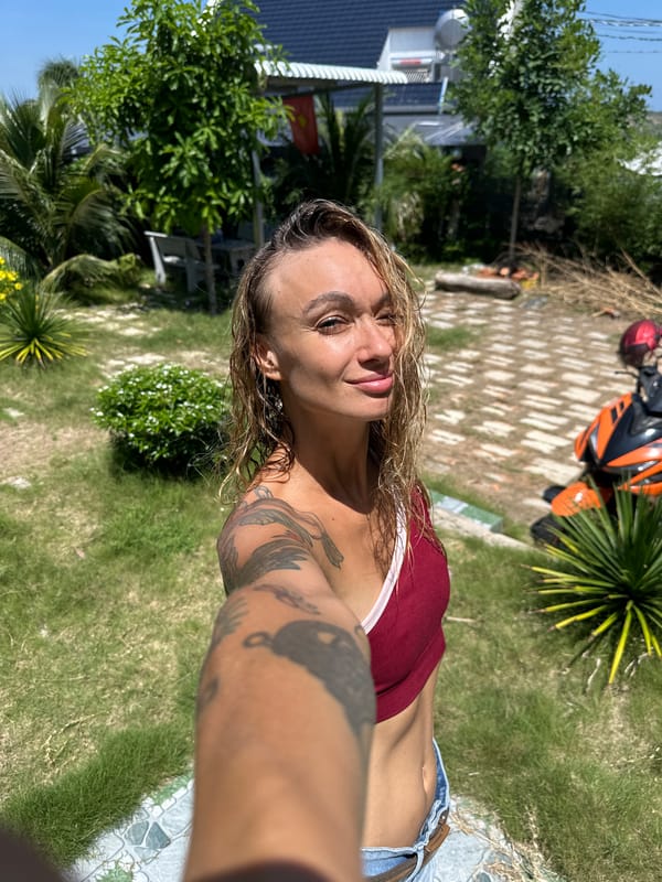 Woman takes selfie in Mũi Né with wet hair, tattoos