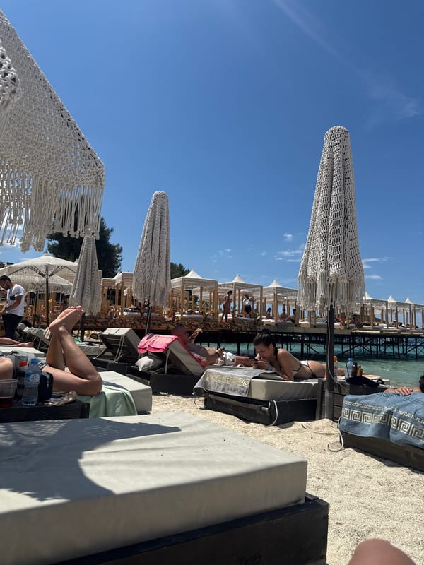 Beachgoers relax under umbrellas at Ksamil, Albania resort