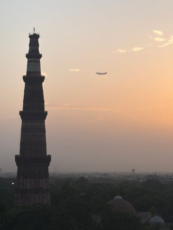 Delhi landmarks and skyline glow under a hazy summer dusk