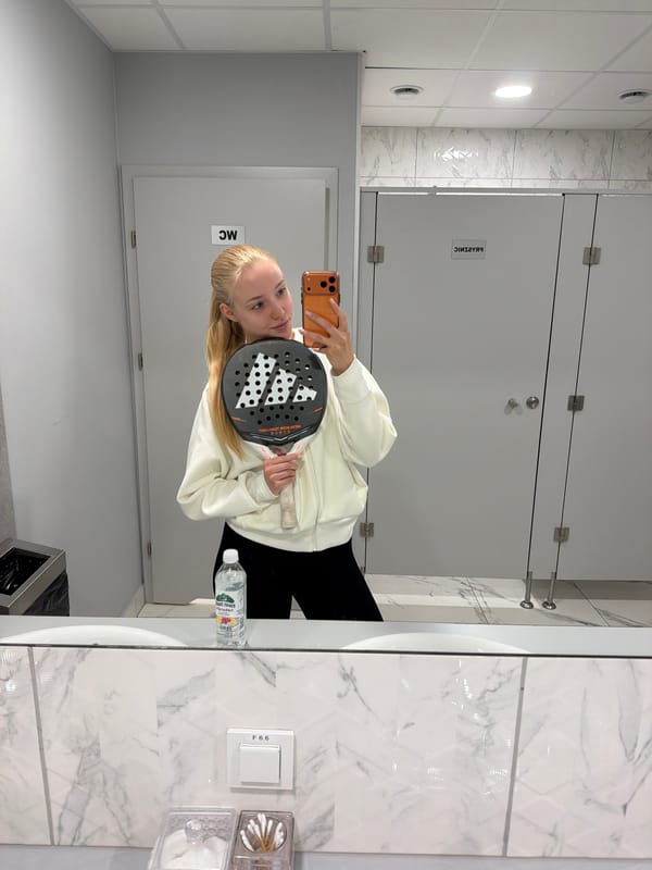 Woman takes restroom selfies with padel racket after court session