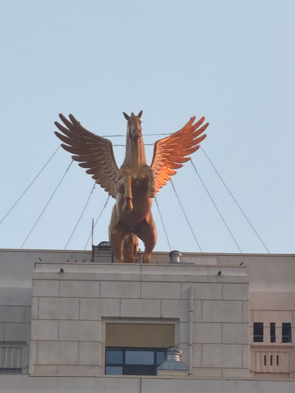 Golden Pegasus statue and waterside activity in Astana