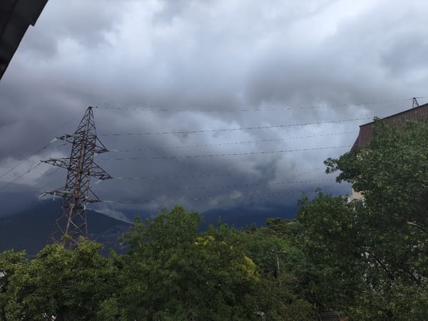 Storm clouds gather while a cat naps peacefully inside near Massandra