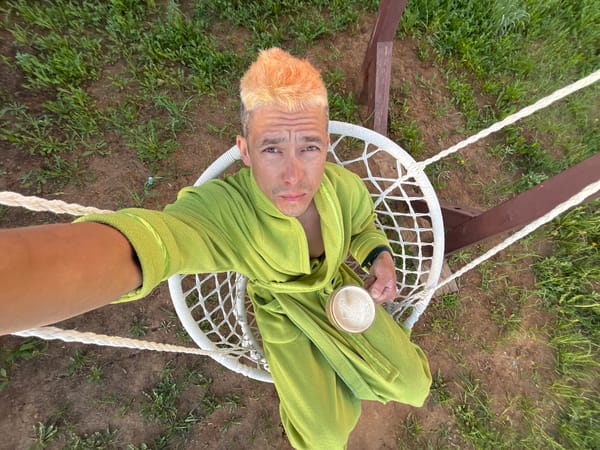 Man enjoys morning beverage in garden hammock in Chaikovsky