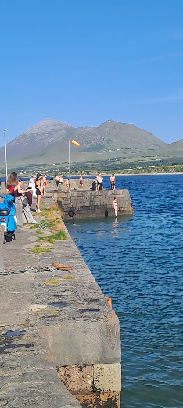Sunny afternoon at an Irish coastal spot with pier and beach.