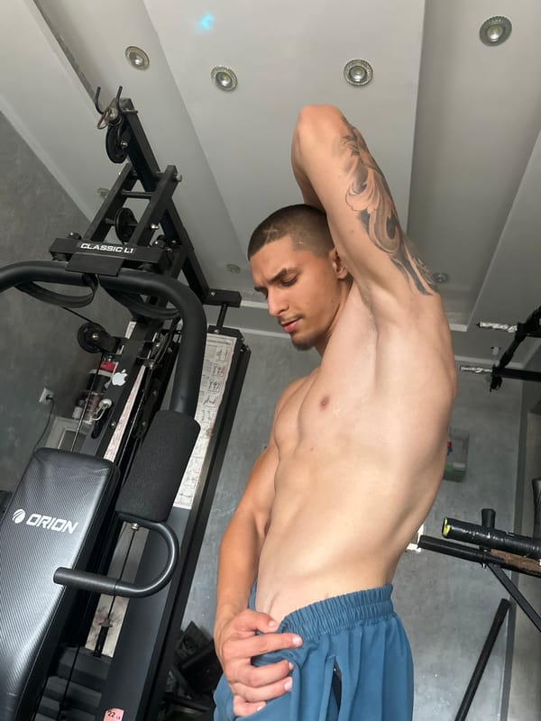 Tattooed man documents workout routine at gym during afternoon session
