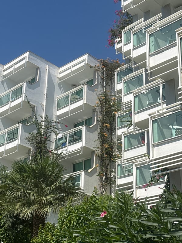 White apartment complex in Bodrum draped in bougainvillea