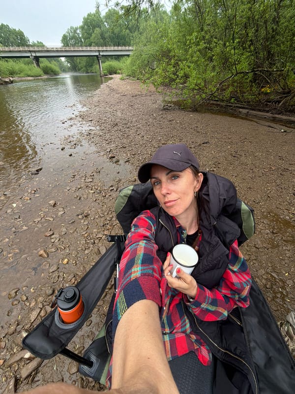 Hiker takes stream break with enamel mug in Russia