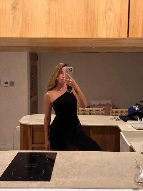Mirror selfies in a modern Mengwi bathroom, black dress and LED light.
